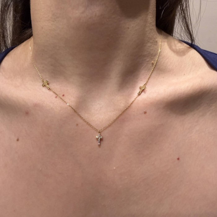 14K gold necklace with central cross and zircon stones, complemented by small cross elements on the chain