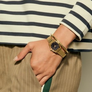 Nixon watch with gold bracelet and black dial